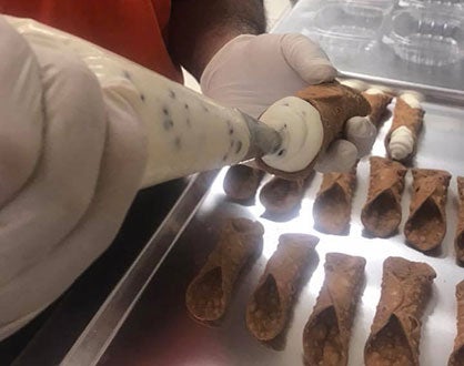 man making cannolis